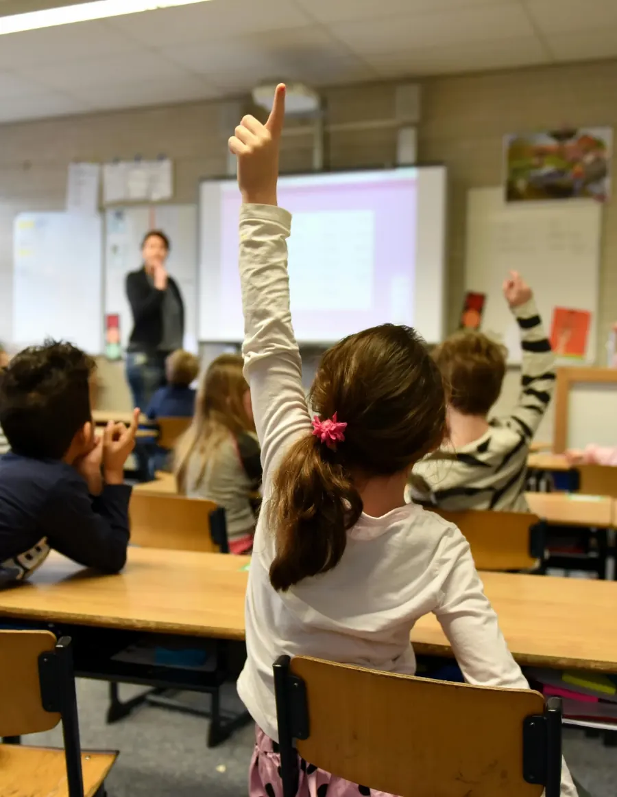 Une élève lève la main pendant un atelier en classe élémentaire